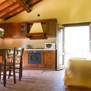 Il soggiorno-cucina con la porta di ingresso verso il giardino