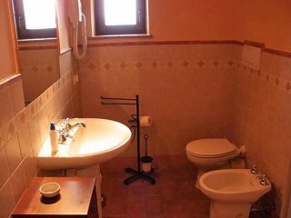 The bathroom has a shower, toilet, bidet, washbasin, hairdryer, window and extractor fan